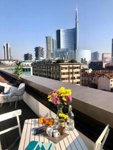 uma mesa numa varanda com vista para a cidade em Attic 9th floor with 2 terrace in Milan Center Brera with amazing view em Milão
