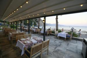 a restaurant with tables and chairs and a view of the ocean at Turunc Premium Hotel in Turunç
