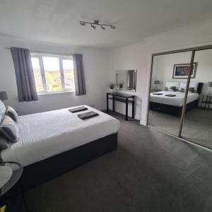 una camera con due letti e un grande specchio di Levenhowe Holiday Apartment a Balloch