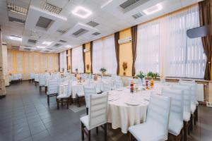 a banquet hall with white tables and white chairs at Motel Piatra Corbului in Bicaz