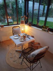 uma mesa e cadeiras num quarto com janelas em Chambre avec entrée indépendante em Esnandes