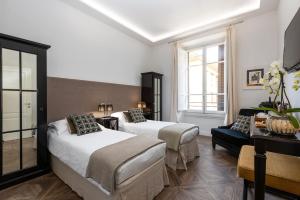 een hotelkamer met 2 bedden en een bank bij RFC Repubblica Florence Core B&B in Florence