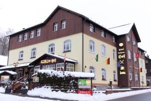 a large building with snow in front of it at Hotel Seiffener Hof*** in Seiffen