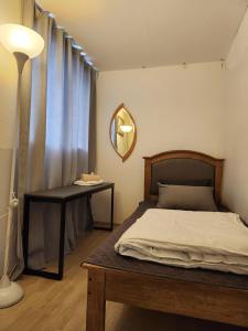 um quarto com uma cama, uma mesa e um espelho em Aark House em Gangneung