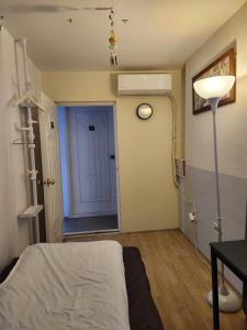 um quarto de hospital com uma cama e uma porta azul em Aark House em Gangneung