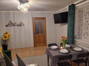 a dining room with a table and chairs and a door at Domek nad potokiem in Kluszkowce