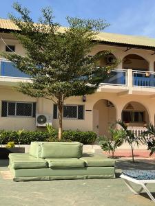 a couch in front of a house with a tree at TRANQUIL RESORT HOTEL in Brusubi