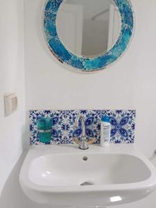 a bathroom sink with a mirror and blue and white tiles at Dar Janis Djerba دار يانيس جربة in Houmt Souk