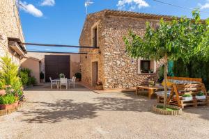 Casa de piedra con patio con mesa y sillas en Casa rural LA PEDANIA 