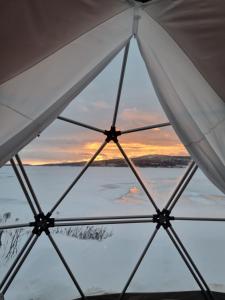 Aussicht von der Innenseite eines Zeltes auf das Wasser in der Unterkunft Røros Arctic Dome in Glåmos