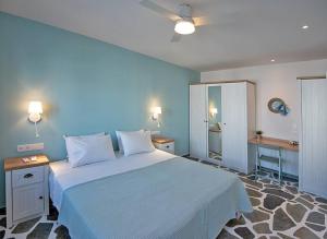 a bedroom with a large white bed with blue walls at Stella's Studio in Galissas