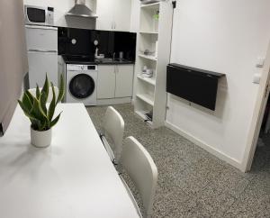 a white kitchen with a white table and chairs at Modern Room with Indoor Shower Near the River - Quarto Moderno com Duche interior Próximo da Ribeira in Vila Nova de Gaia