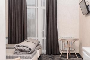 a room with a bed and a table and a window at Silveroks Apartment in Prilimanskoye