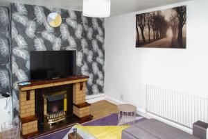 a living room with a fireplace and a tv at Allen Wednesbury Accommodation in Darlaston