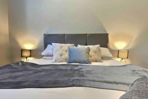 a bedroom with a large bed with two lamps at Cotswold Chapel, sleeps up to 5 in kingsize beds in Chipping Norton