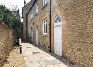 un edificio in mattoni con una porta bianca e una strada di Cotswold Chapel, sleeps up to 5 in kingsize beds a Chipping Norton