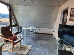 een woonkamer met een tafel en een televisie bij Ferienwohnungen Dagmar in Kurort Oberwiesenthal