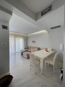 - un salon avec une table blanche et un canapé dans l'établissement Villa Theodora in front of the sea, à Chaniotis