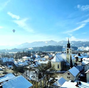 a small town with snow covered roofs and a church at Sanosueno 1 in Sonthofen