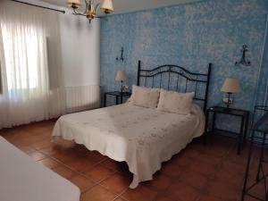 1 dormitorio con 1 cama con pared azul en Casa Rural Cortijo la Jimena, en Prados