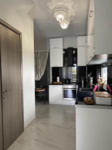 a kitchen with white cabinets and a counter top at Villa Theodora in front of the sea in Hanioti