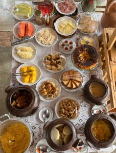 a table topped with lots of different types of food at Pousada Matuto Sonhador in Cabaceiras