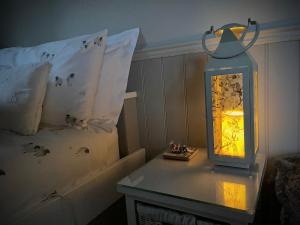 a lantern sitting on a table next to a bed at Poachers Hut at Keepers Cottage - Hot Tub & Pizza Oven - Trossachs in Port of Menteith