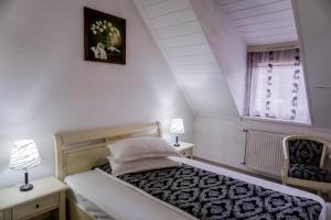 a bedroom with a bed and two tables and a window at Hotel Claudiu in Sighişoara