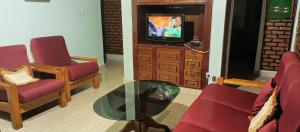 a living room with two chairs and a glass table at Charming 2-Bed House in Kigali in Kigali