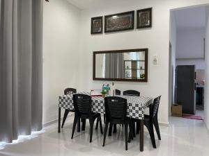 Merlimau的住宿－RB HOMESTAY，餐桌、黑色椅子和镜子