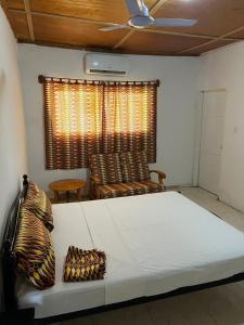 a large bed in a room with a window at TRANQUIL RESORT HOTEL in Brusubi