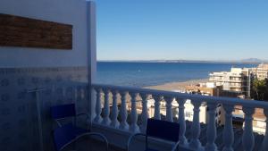 a balcony with chairs and a view of the ocean at Ático Berni in Santa Pola