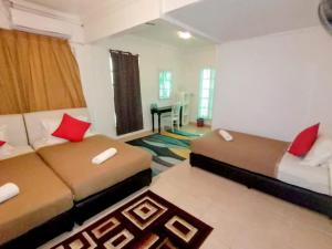 uma sala de estar com duas camas e um sofá em Fishing Village Marang Terengganu em Marang