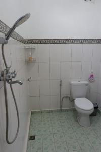 a bathroom with a toilet and a shower at Karauci Homestay in Abeansemal