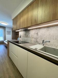 a kitchen with white cabinets and a sink at Apartments Vaiolet in Santa Cristina Gherdëina