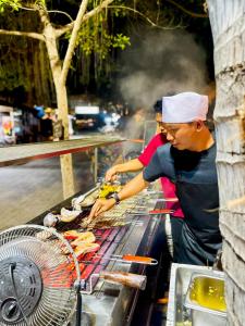 a man and woman cooking food on a grill at Zipp Bar Restaurant & Bungalows in Gili Air