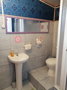 a bathroom with a sink and a toilet at "Mi Hostal Tu Casa" Hostal Familiar SOLO EMPRESAS, TURISTAS y VIAJEROS Espacio para BICICLETAS y MOTOS in Puerto Montt +34 photos