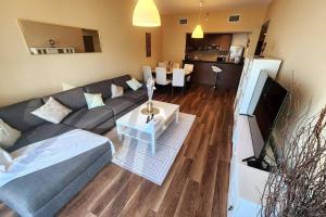 a living room with a gray couch and a table at Cozy 1BR in Gate Tower in Abu Dhabi