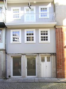 une maison blanche avec un balcon dans une rue dans l'établissement Santa Luzia Apartments By Guestify, à Guimarães