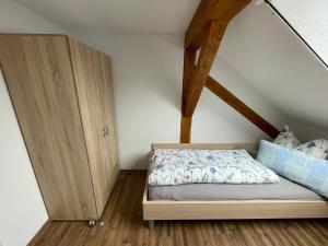 1 dormitorio con 1 cama y armario de madera en Ferienwohnung Niederrotweil, en Niederrotweil