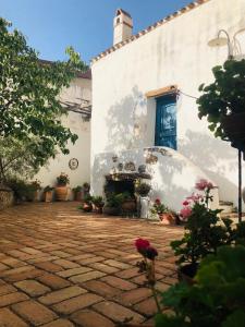 einen Innenhof mit einem weißen Gebäude mit Blumen und Pflanzen in der Unterkunft B&B Corte San Lussorio in Oliena