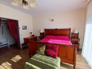 a bedroom with a wooden bed with a pink bedspread at Apartments Orange Lovran in Lovran