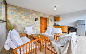 ein Wohnzimmer mit einem Tisch, Stühlen und einer Steinmauer in der Unterkunft Gorgeous Home In Visoko With Wifi in Visoko