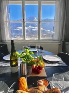 湖畔捷爾的住宿－4 SEASON LODGE，一张桌子,上面放着一盘食物和一瓶葡萄酒
