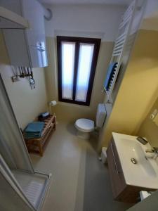 ein Bad mit einem WC, einem Waschbecken und einem Fenster in der Unterkunft Appartamento Sophie LT in Santa Maria Maggiore