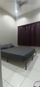 Bett in einem Zimmer mit Vorhang in der Unterkunft Al Irfan Homestay Tmn SgDua Utama in Butterworth