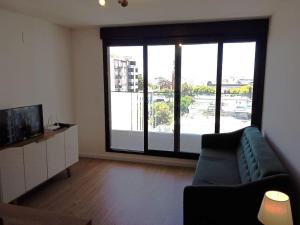 a living room with a couch and a large window at A estrenar en Punta Carretas in Montevideo