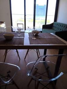 a wooden table with two chairs and wine glasses at A estrenar en Punta Carretas in Montevideo