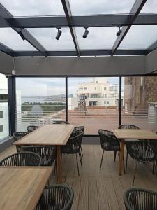 eine Cafeteria mit Holztischen, Stühlen und Fenstern in der Unterkunft A estrenar en Punta Carretas in Montevideo