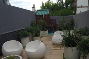 a row of white chairs and potted plants on a patio at A estrenar en Punta Carretas in Montevideo